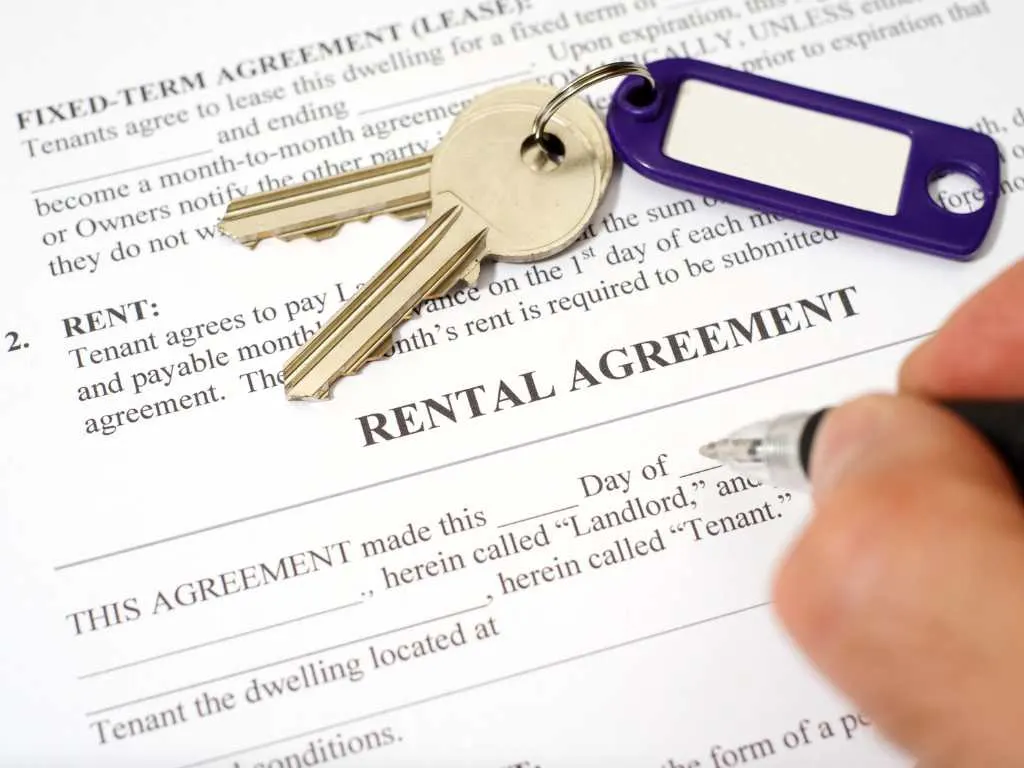 Rental agreement document with house keys and pen for a tenancy template